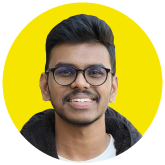 A smiling man with short black hair, glasses, and a beard wears a dark jacket over a white shirt, embodying the modern style of a creative agency. The background is a bright yellow circle. A smiling man with short black hair, glasses, and a beard wears a dark jacket over a white shirt, embodying the modern style of a creative agency. The background is a bright yellow circle.